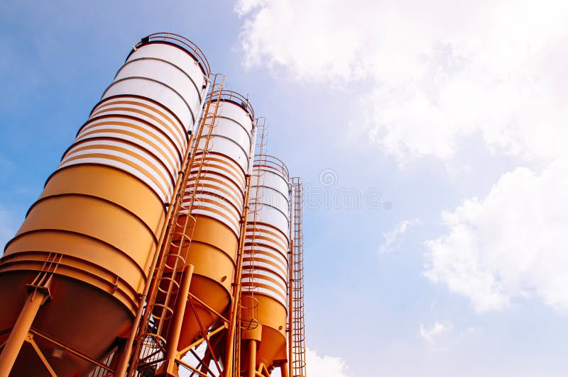 Cement silos of Cement batching plant factory against evening warm clear sky with space for text. Cement silos of Cement batching plant factory against evening warm clear sky with space for text