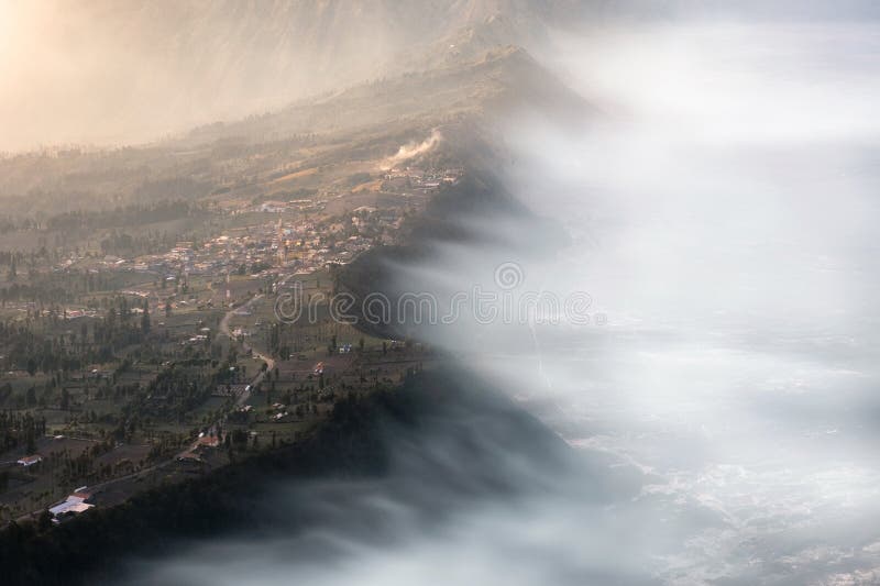 Cemoro Lawang village on mountain cliff with foggy in sunrise. Bromo tengger semeru national park, East Java, Indonesia stock photo Cemoro Lawang village on mountain cliff with foggy in sunrise. Bromo tengger semeru national park, East Java, Indonesia stock photo
