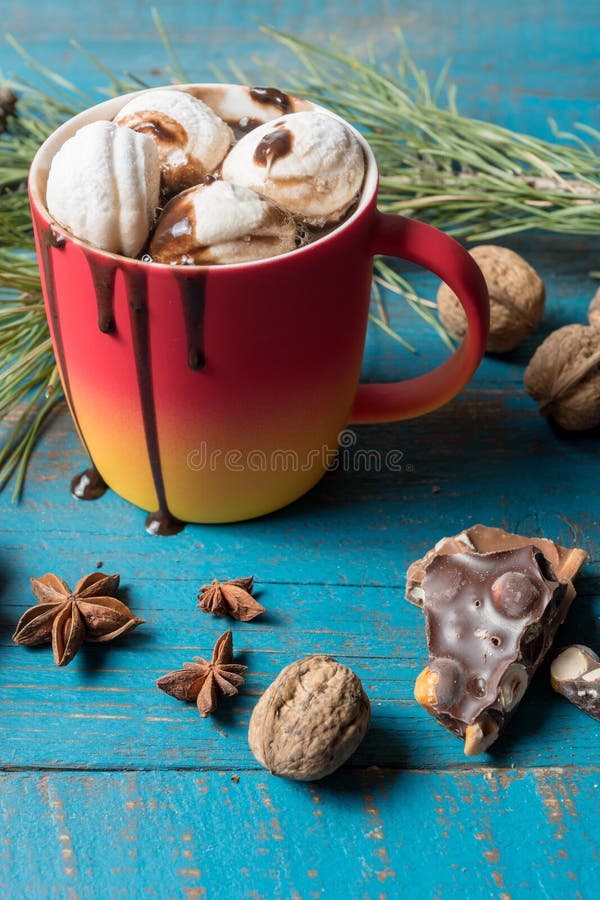 Cena acolhedor antes da chaminé com a caneca vermelha de chocolate quente, de marshmallows, de porcas e de citrinas ferventadas c fotos de stock royalty free Cena acolhedor antes da chaminé com a caneca vermelha de chocolate quente, de marshmallows, de porcas e de citrinas ferventadas c fotos de stock royalty free