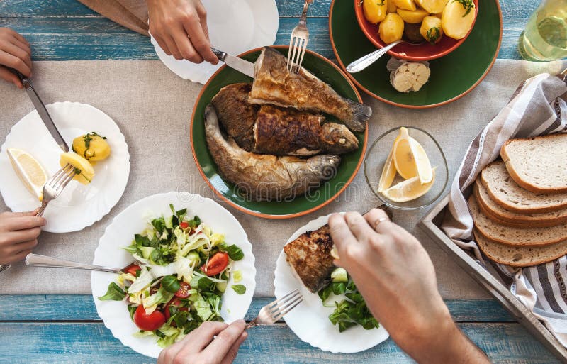 Cena con il pesce fritto, le patate e l'insalata fresca immagine stock libera da diritti Cena con il pesce fritto, le patate e l'insalata fresca immagine stock libera da diritti