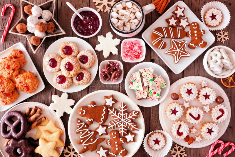 Cena da mesa de assar de Natal com vários doces e biscoitos, vista de cima sobre um fundo de madeira rústica