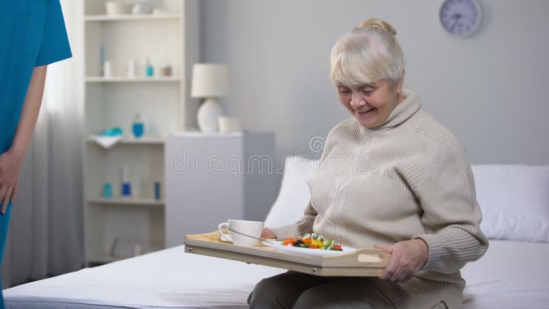 Cena a la señora mayor feliz, buenos servicios del hospital, cuidado de la porción del trabajador médico