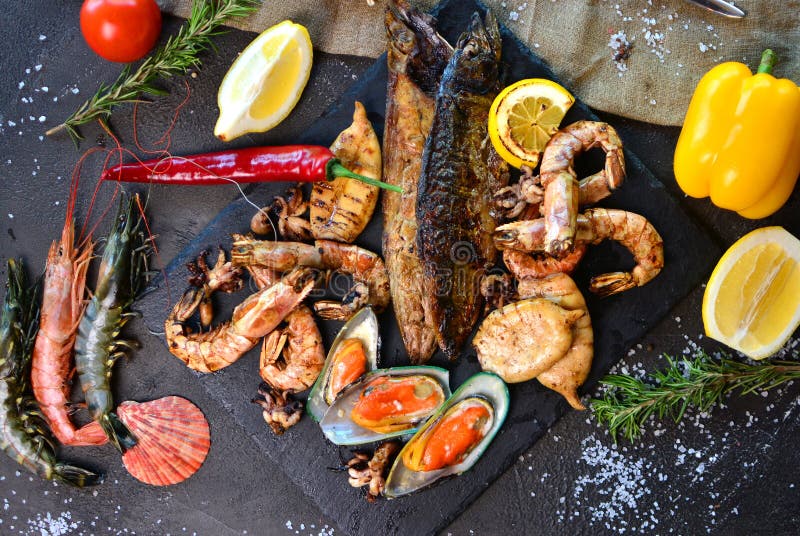 Cena mediterránea con los camarones, los mejillones, los calamares y los pescados asados a la parrilla fotos de archivo libres de regalías Cena mediterránea con los camarones, los mejillones, los calamares y los pescados asados a la parrilla fotos de archivo libres de regalías