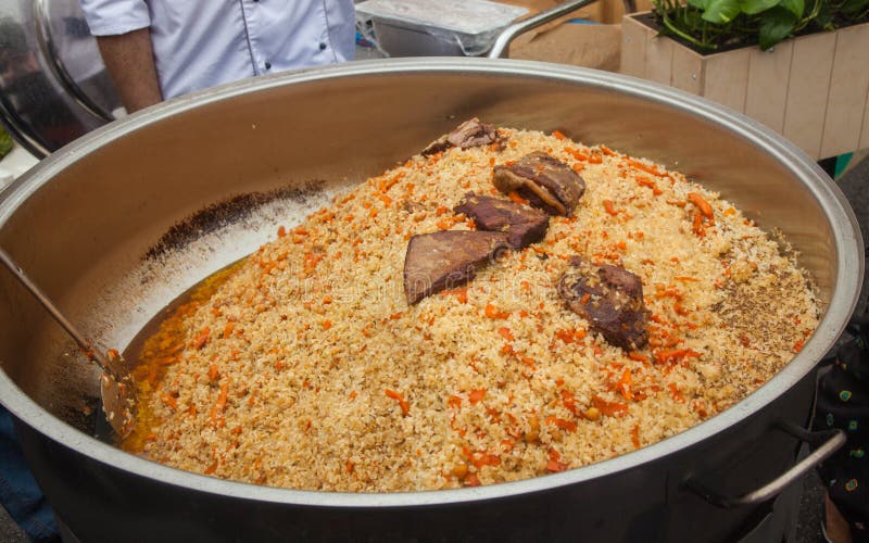 Central Asian pilaf with meat in a large cauldron. Traditional big metal pot stock images, royalty-free photos and pictures