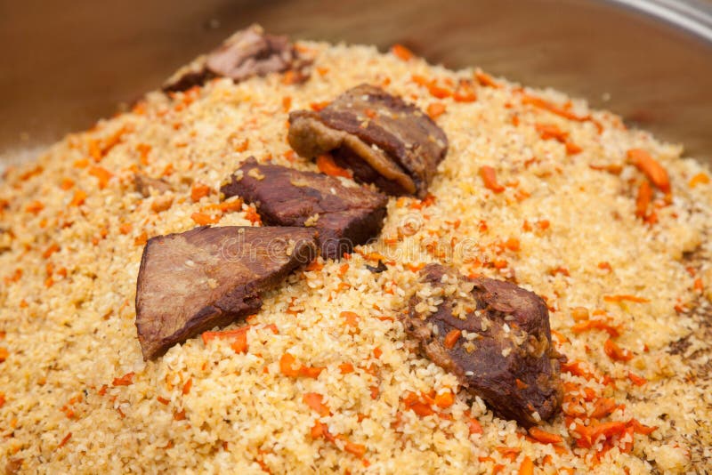 Central Asian pilaf with meat in a large cauldron. Traditional big metal pot stock images, royalty-free photos and pictures