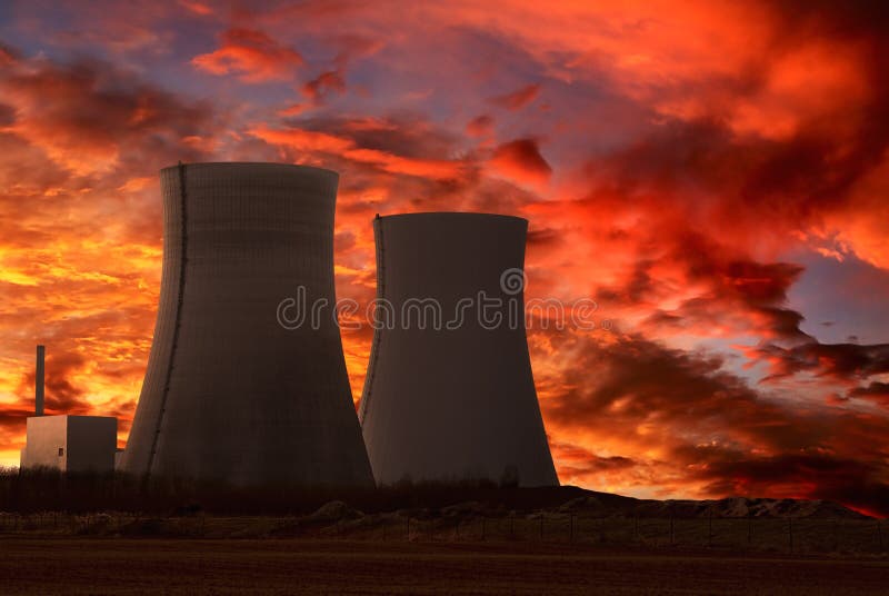 Central nuclear com um céu vermelho intenso imagens de stock