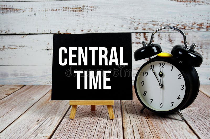 Central Time text with easel and alarm clock on wooden background stock photography