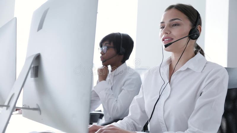 Centro de chamadas Mulher de sorriso no funcionamento dos auriculares no computador