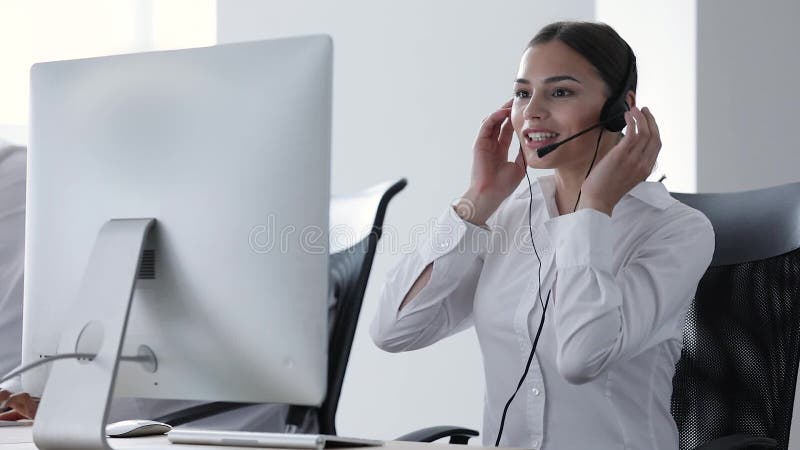 Centro de chamadas Operador da mulher nos auriculares no apoio da linha de apoio ao cliente