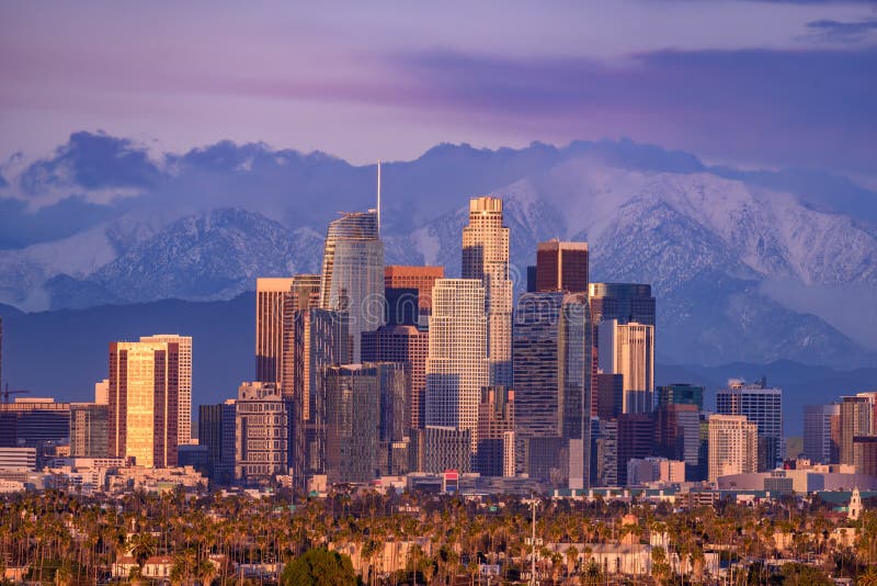 Downtown Los Angeles skyline with snow capped mountains behind at sunset. Downtown Los Angeles skyline with snow capped mountains behind at sunset