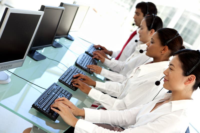 Multi ethnic call center operators in a row at workplace. Multi ethnic call center operators in a row at workplace