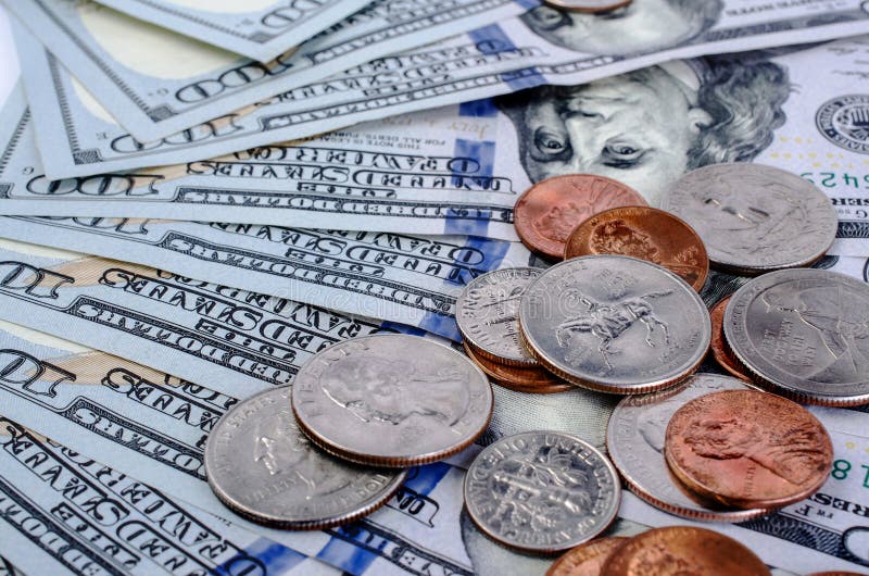 Cents of different denominations on top of hundred dollar bill.