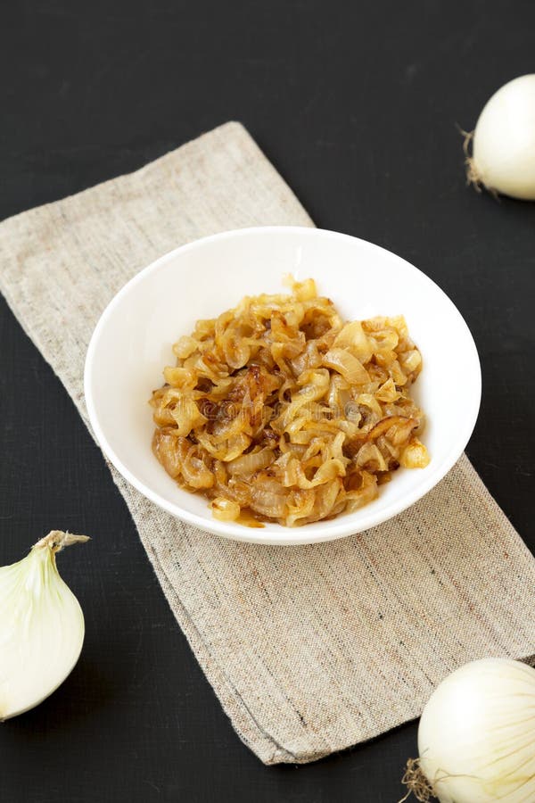 Cepe caramelizate realizate în casă pe o placă albă, cu un unghi de vedere inferior, la suprafață neagră stock photography