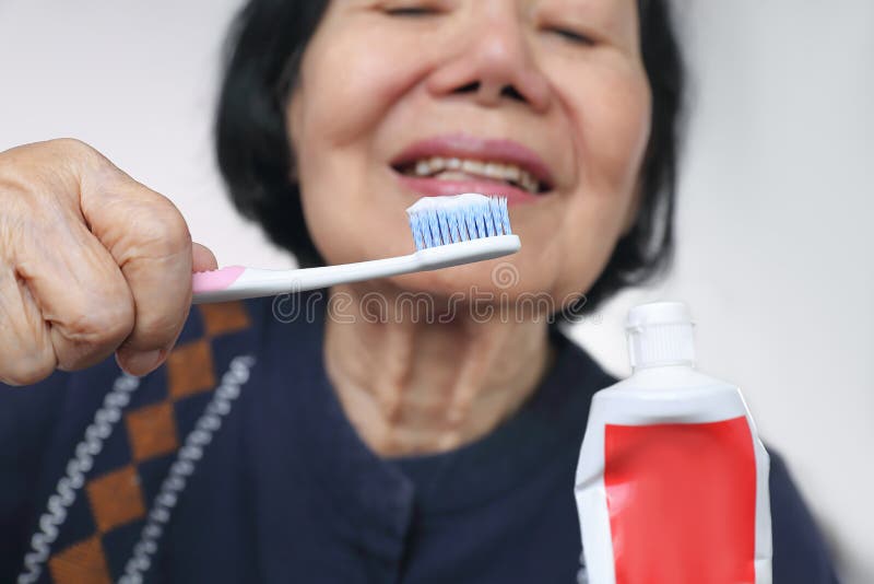 Cepillo de dientes del uso de la mujer que intenta mayor asiática dental fotos de archivo libres de regalías Cepillo de dientes del uso de la mujer que intenta mayor asiática dental fotos de archivo libres de regalías