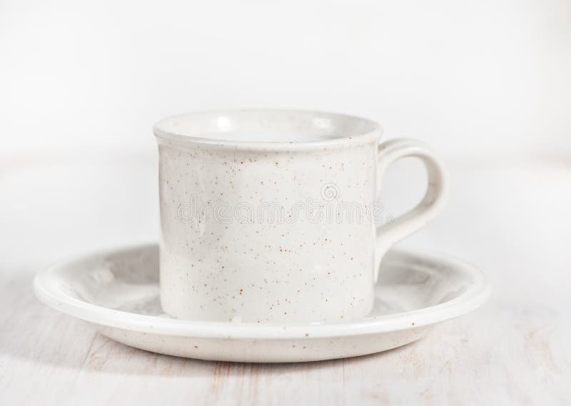 Ceramic mug with milk and saucer