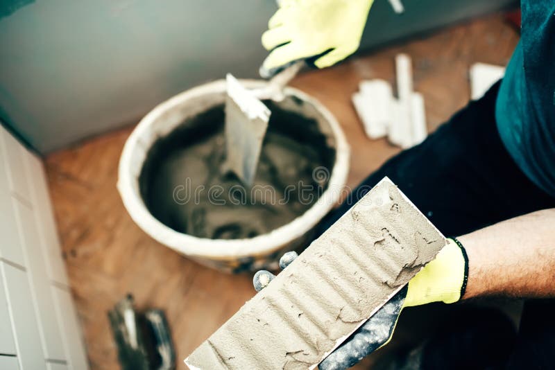 Installing ceramic tiles details. Interior design renovation close up. Worker adding adhesive on ceramic tiles. Bricklayer tiler stock images, royalty-free photos and pictures