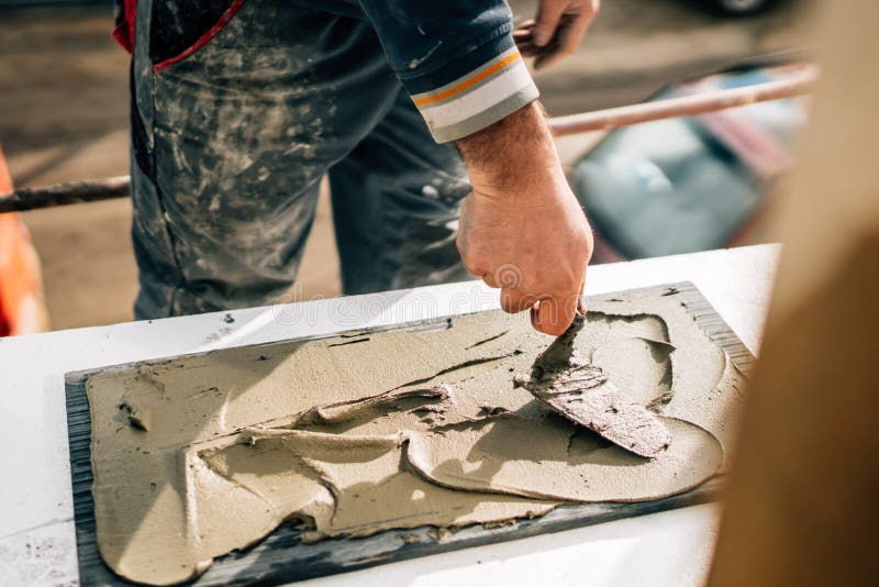 Ceramic tiles. the worker`s hand adding adhesive on marble, stone. Bricklayer tiler stock images, royalty-free photos and pictures