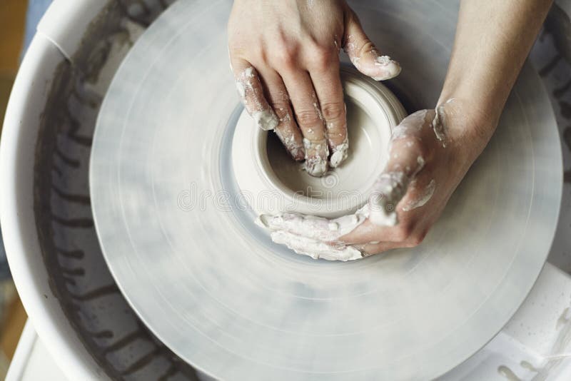 Ceramic working process with clay potter`s wheel, close-up of woman hands. stock photo