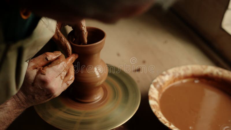 Ceramist die kleipot produceert in aardewerk. niet-erkende man die met natte klei werkt