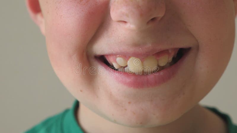 Cerca de la sonrisa del niño. Retrato del muchacho hermoso con expresión alegre en cara. Dictamen del detalle buena cara de niño