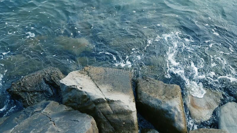Cerca de olas rodando sobre roca en una playa metrajes