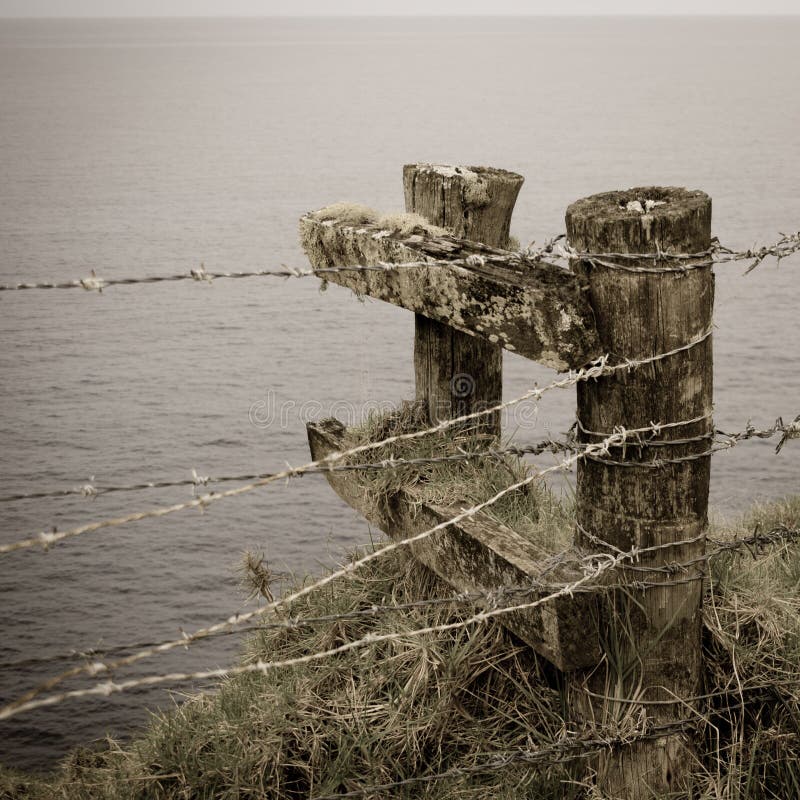 Cerca do arame farpado e cargos, Ilhas Norfolk imagem de stock Cerca do arame farpado e cargos, Ilhas Norfolk imagem de stock