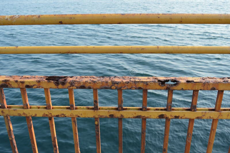 Cerca y mar aherrumbrados amarillos en fondo imagen de archivo libre de regalías Cerca y mar aherrumbrados amarillos en fondo imagen de archivo libre de regalías