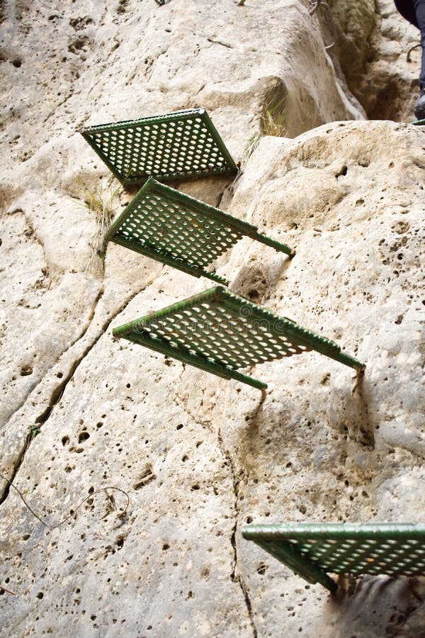 cercano para arriba de algunos pasos verdes para subir una piedra blanca vertical de la pared de una montaña que ayuda a los cami foto de archivo cercano para arriba de algunos pasos verdes para subir una piedra blanca vertical de la pared de una montaña que ayuda a los cami foto de archivo