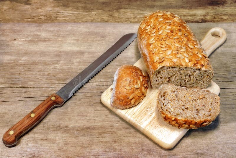 Cereal Bread Loaf with Grains and slicer knife in rustic still-life, XXXL