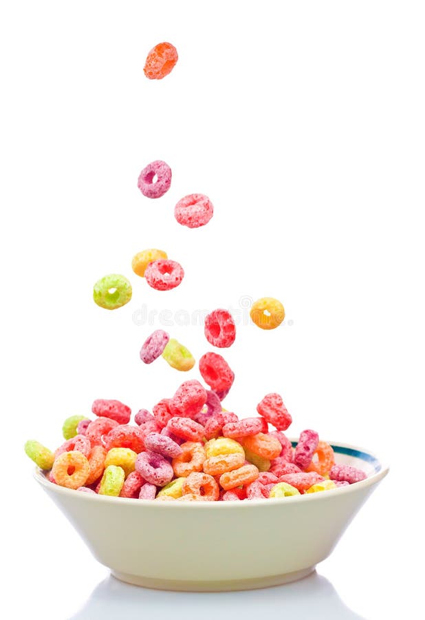 Cereal colorido que cae en un tazón de fuente blanco