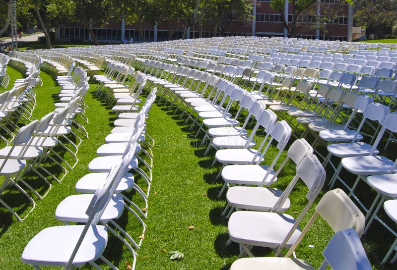 Rows of white chairs arranged for a graduation ceremony. Rows of white chairs arranged for a graduation ceremony.