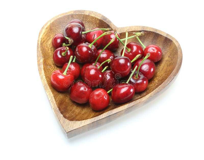 Cerezas en una placa de madera en forma de corazón imágenes de archivo libres de regalías Cerezas en una placa de madera en forma de corazón imágenes de archivo libres de regalías