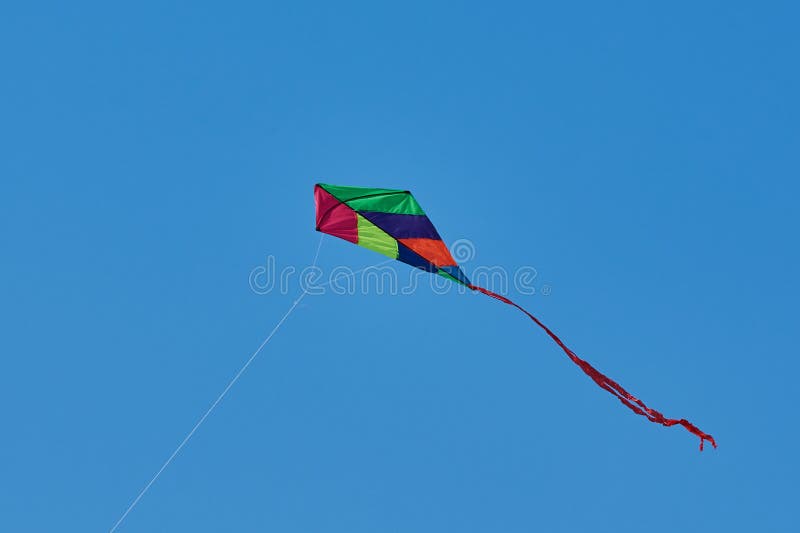 Cerf-volant coloré de jouet contre le ciel bleu images stock Cerf-volant coloré de jouet contre le ciel bleu images stock