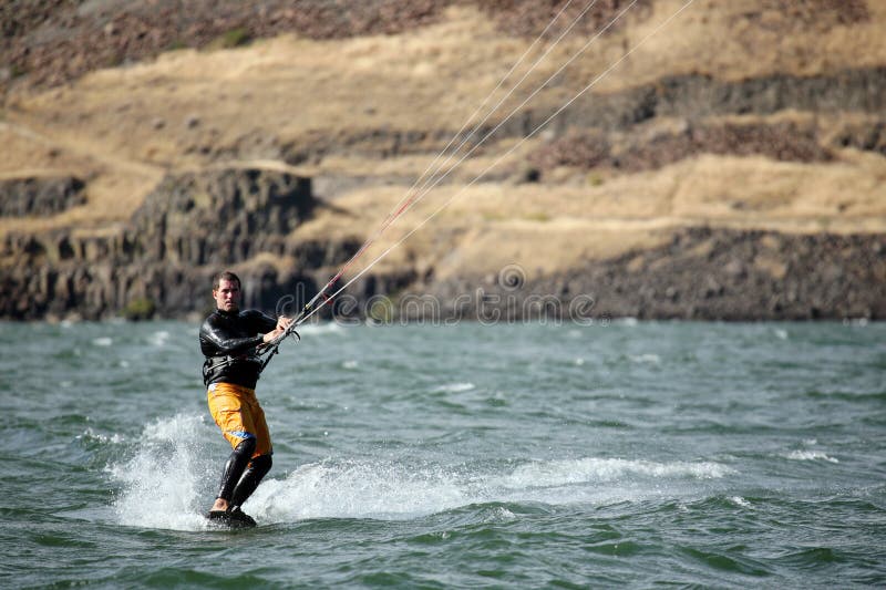 Cerf-volant d'homme surfant sur le fleuve photo libre de droits Cerf-volant d'homme surfant sur le fleuve photo libre de droits