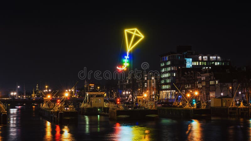 Cerf-volant de lampe au néon au-dessus du port d'Amsterdam image stock Cerf-volant de lampe au néon au-dessus du port d'Amsterdam image stock