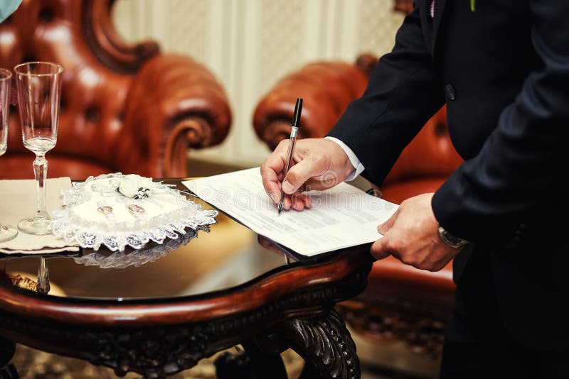 Cerimonia di cerimonia nuziale Equipaggi il contratto di matrimonio di firma, il primo piano, lo sposo s fotografie stock libere da diritti Cerimonia di cerimonia nuziale Equipaggi il contratto di matrimonio di firma, il primo piano, lo sposo s fotografie stock libere da diritti