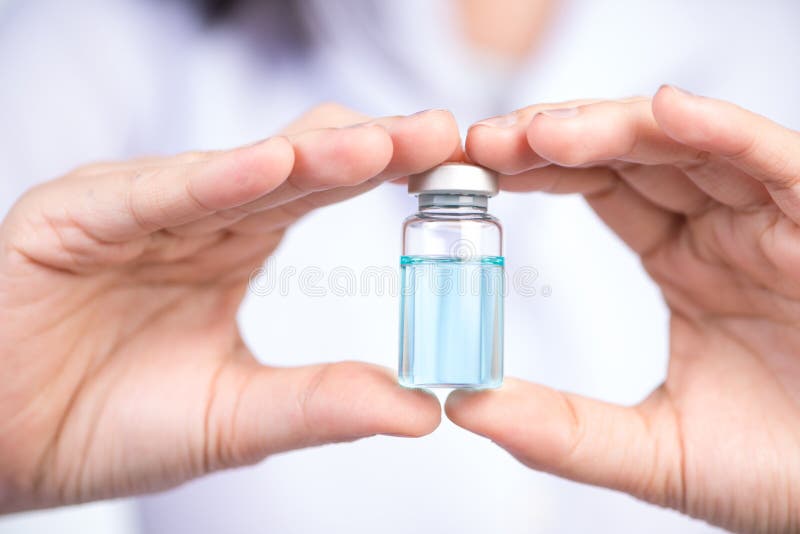Cerrado encima de la mano del frasco de la inyección del control de la enfermera imagen de archivo libre de regalías Cerrado encima de la mano del frasco de la inyección del control de la enfermera imagen de archivo libre de regalías