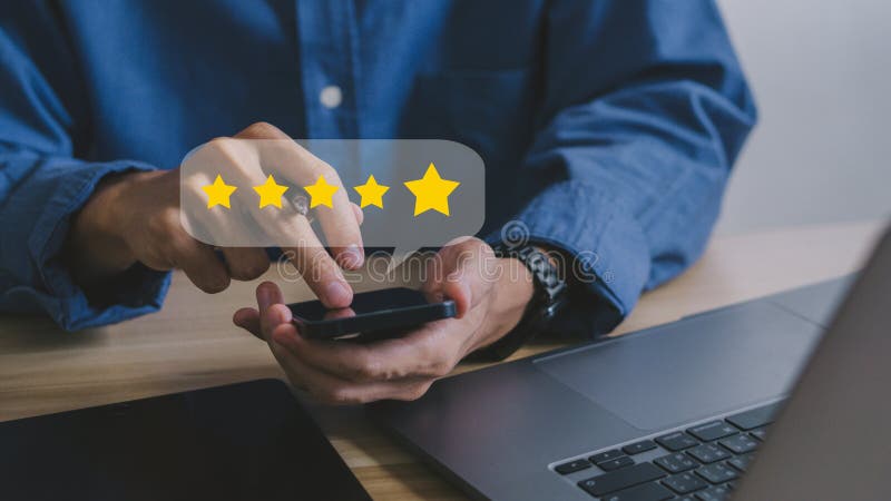 Cerrar con la mano del cliente pulsando en la pantalla del smartphone con un icono de realimentación de cinco estrellas de oro y u fotos de archivo