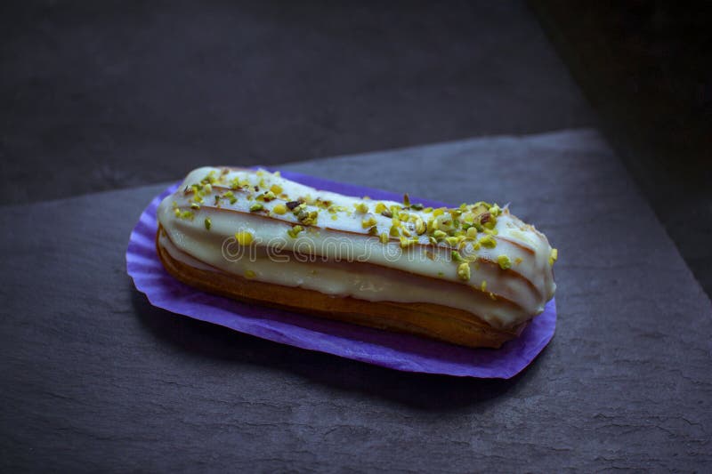 Cerrar deliciosa tarta de eclair con sabor a pistacho cubierta con crema imagen de archivo libre de regalías