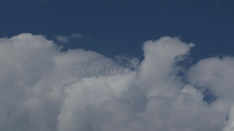 Cerrar el video de 4k time lapse de 4 mil de nubes grandes blancas en un cielo azul soleado.