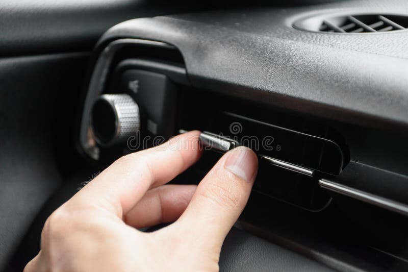 Cerrar la mano del conductor ajusta la dirección del viento de la salida de aire en el ajuste de dirección del botón del coche mod fotos de archivo libres de regalías
