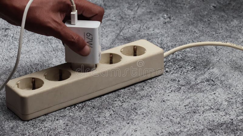 Cerrar mano macho insertar un enchufe del adaptador de teléfono almacen de video