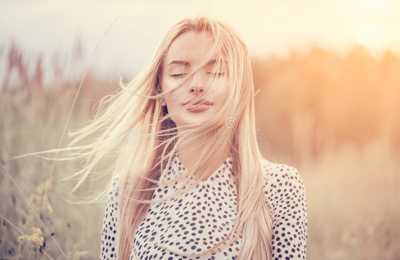 Cerrar Retrato de una chica de belleza con el pelo blanco revoloteando disfrutando de la naturaleza al aire libre, en un campo. Ca foto de archivo libre de regalías