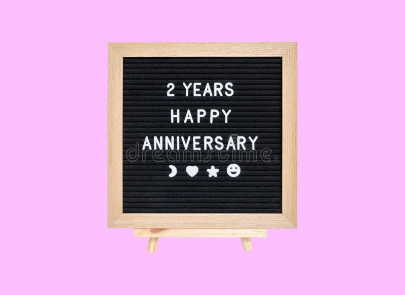 Closeup board with 2 years happy anniversary word isolated on pink background. Closeup board with 2 years happy anniversary word isolated on pink background