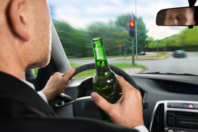Cerveja bebendo do homem de negócios ao conduzir o carro fotos de stock royalty free Cerveja bebendo do homem de negócios ao conduzir o carro fotos de stock royalty free