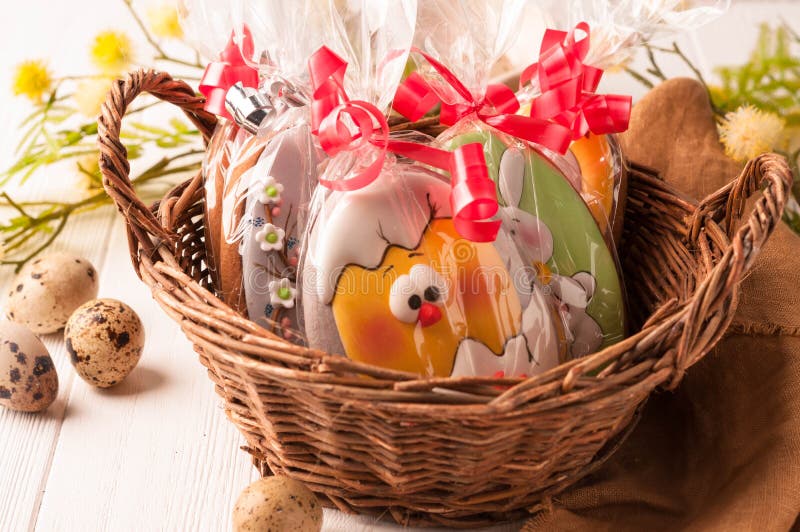 Cesta marrón de mimbre con las galletas envueltas de pascua cerca de los huevos de codornices y de la rama floreciente imagenes de archivo Cesta marrón de mimbre con las galletas envueltas de pascua cerca de los huevos de codornices y de la rama floreciente imagenes de archivo