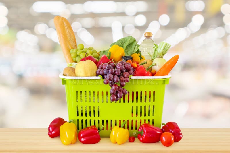 Cesto de compras enchido com as frutas e legumes na tabela de madeira imagens de stock Cesto de compras enchido com as frutas e legumes na tabela de madeira imagens de stock