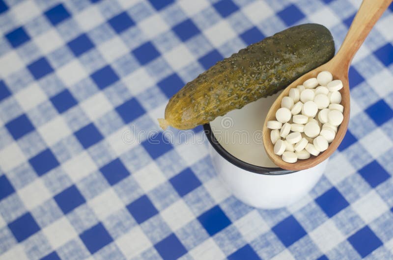 Salted cucumber, mug with milk and anti diarrhea pills. Salted cucumber, mug with milk and anti diarrhea pills