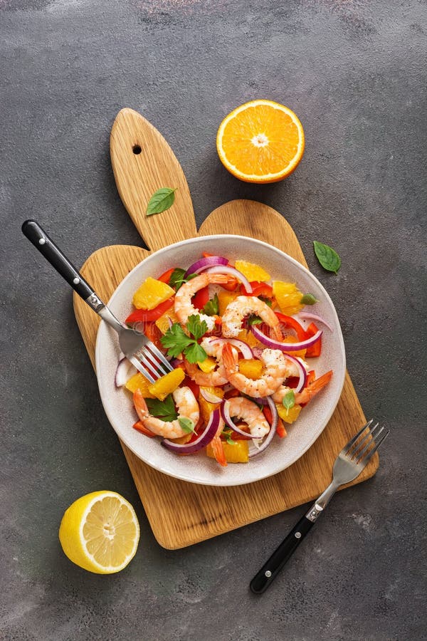 Ceviche with shrimps and orange in a plate on a cutting board. Flat lay, overhead view stock images