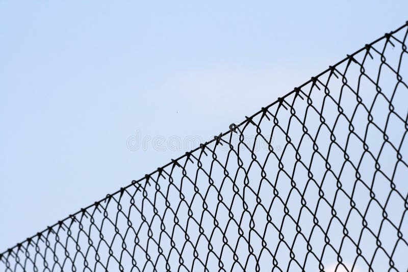 Chainlink fence against blue background. Chainlink fence against blue background